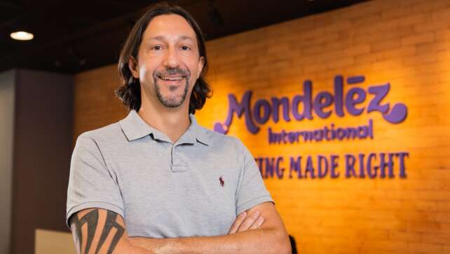 Alvaro Garcia, CMO da Mondelez, de braços cruzados, em frente à parede com a marca