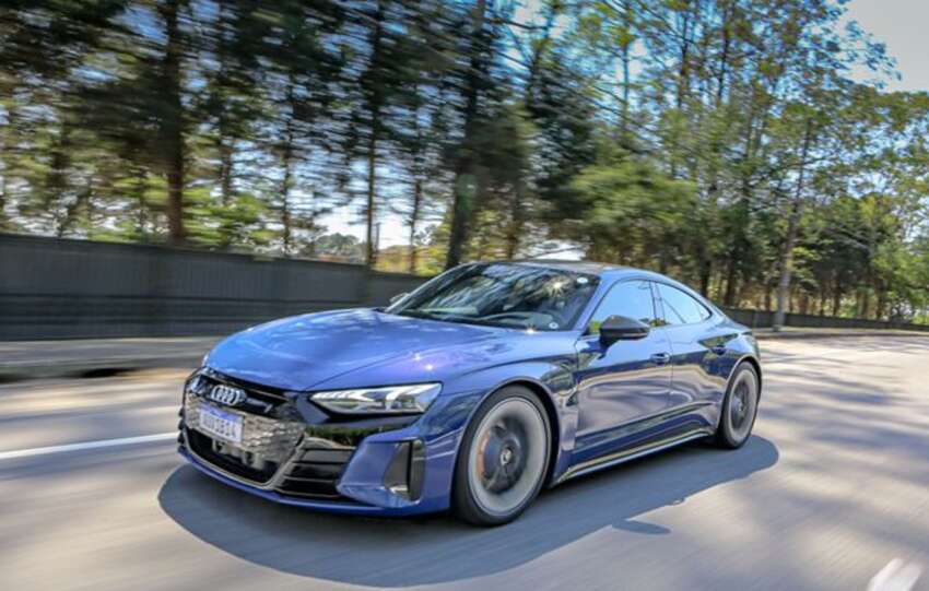 Audi RS E-Tron azul rodando por uma avenida arborizada